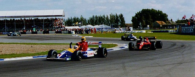 Silverstone 1991 – Nigel Mansell offre un passaggio ad Ayrton Senna sulla sua Williams FW14 dopo il trionfo in gara. Un’iconica immagine di sportività che ha fatto la storia della Formula 1.